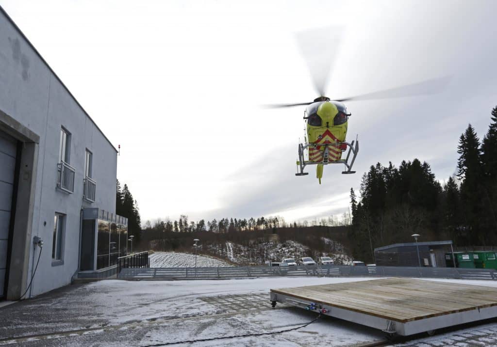 Ambulansehelikopter rett før landing på plattform utenfor basen. 