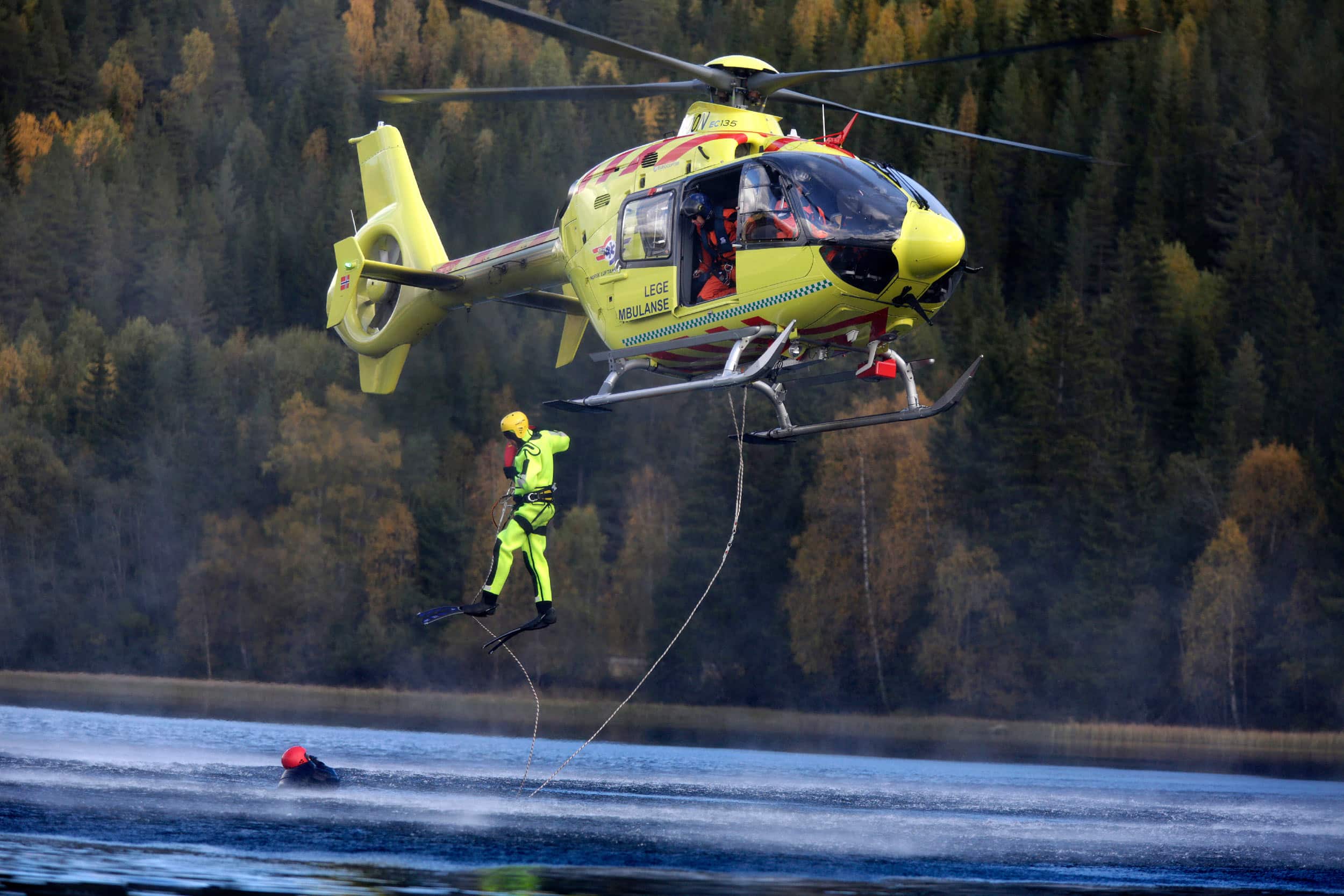 Redningsmann som hoper ut av helikopteret over vann