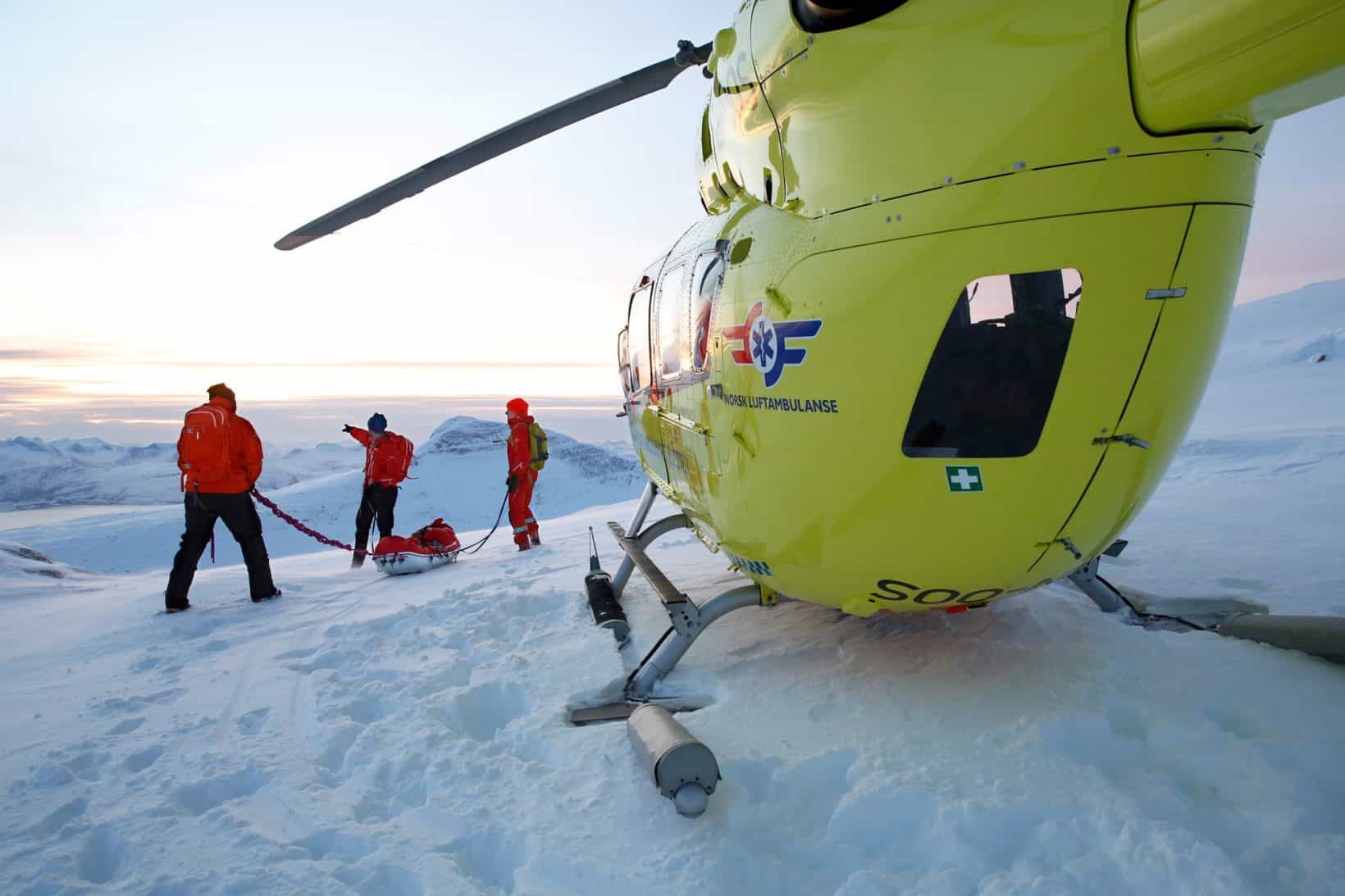 Picture of helicopter on ground with crew standing outside.